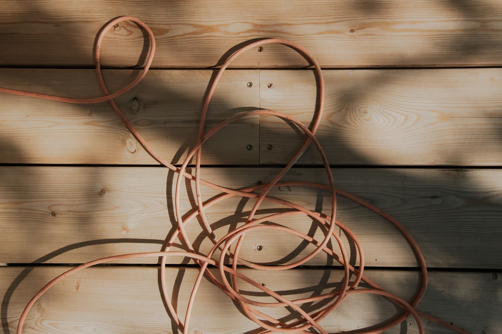 A heavy orange extension cord running across the ground outdoors