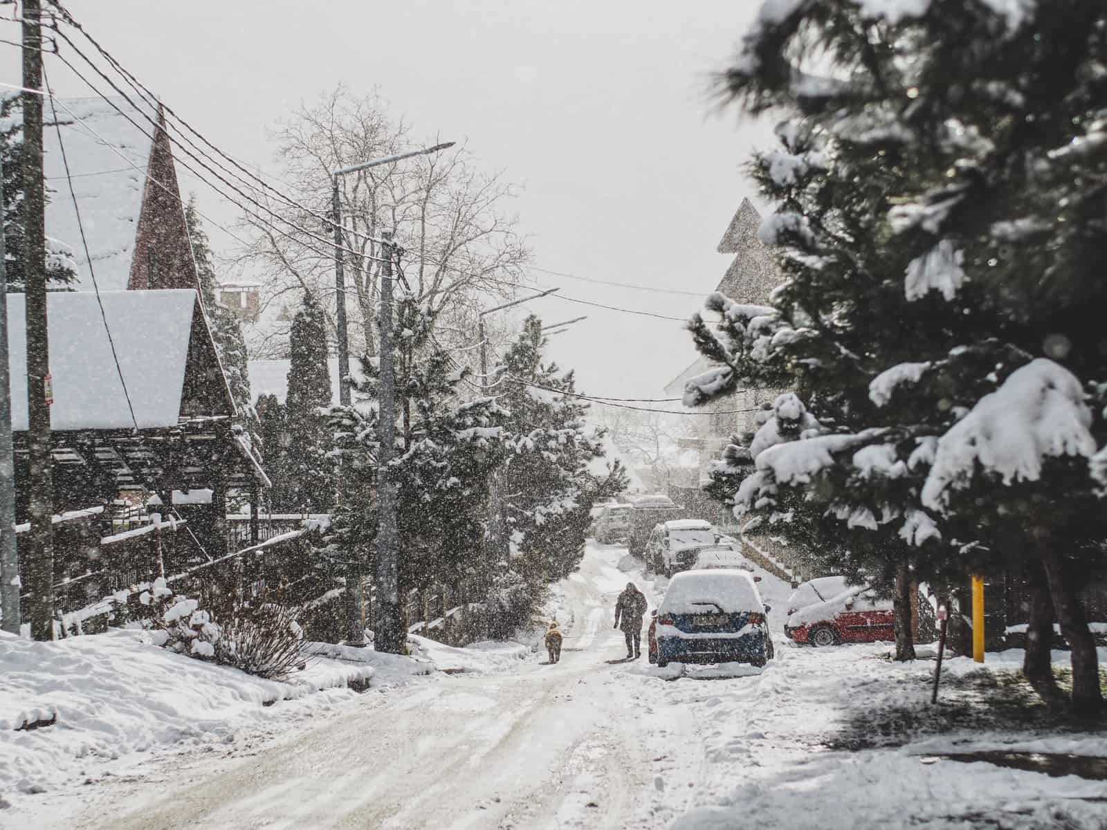 An electric car parked and charging in snowy winter conditions