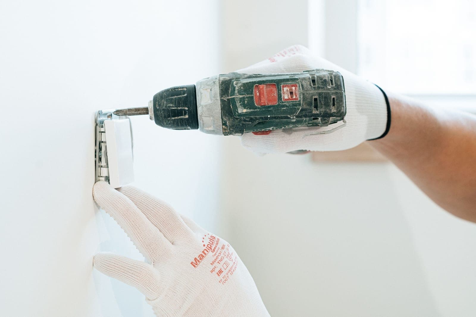An electrician working on an electrical outlet