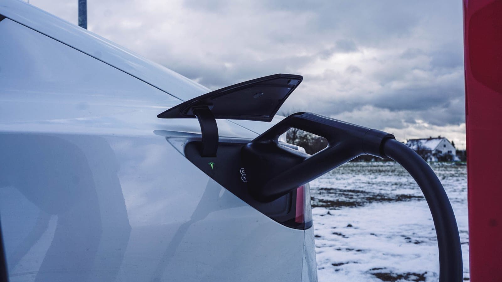 An electric car charging outdoors in winter conditions