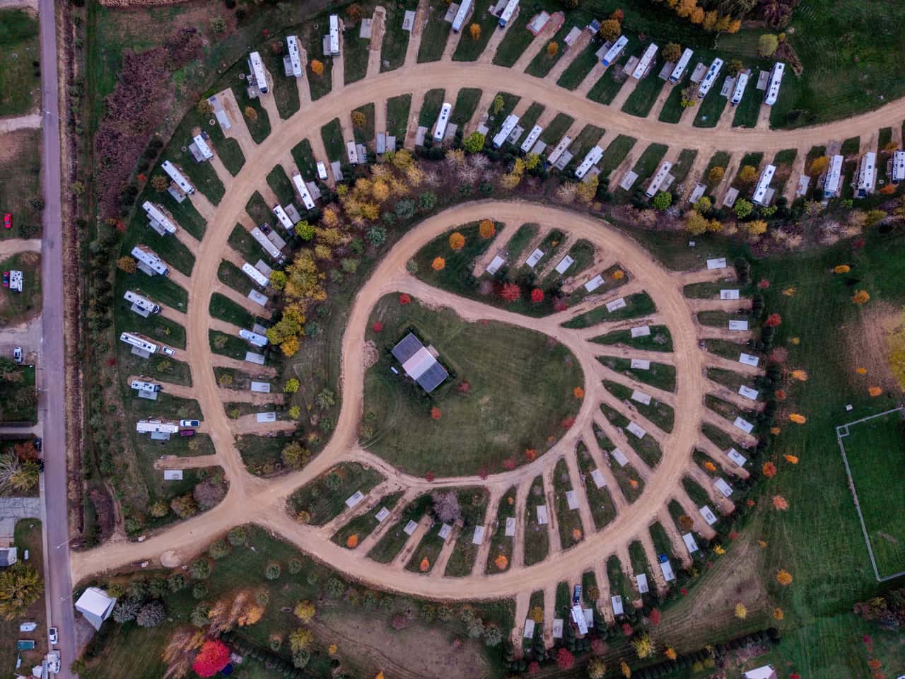 Aerial view of an RV park with rows of campers on marked sites