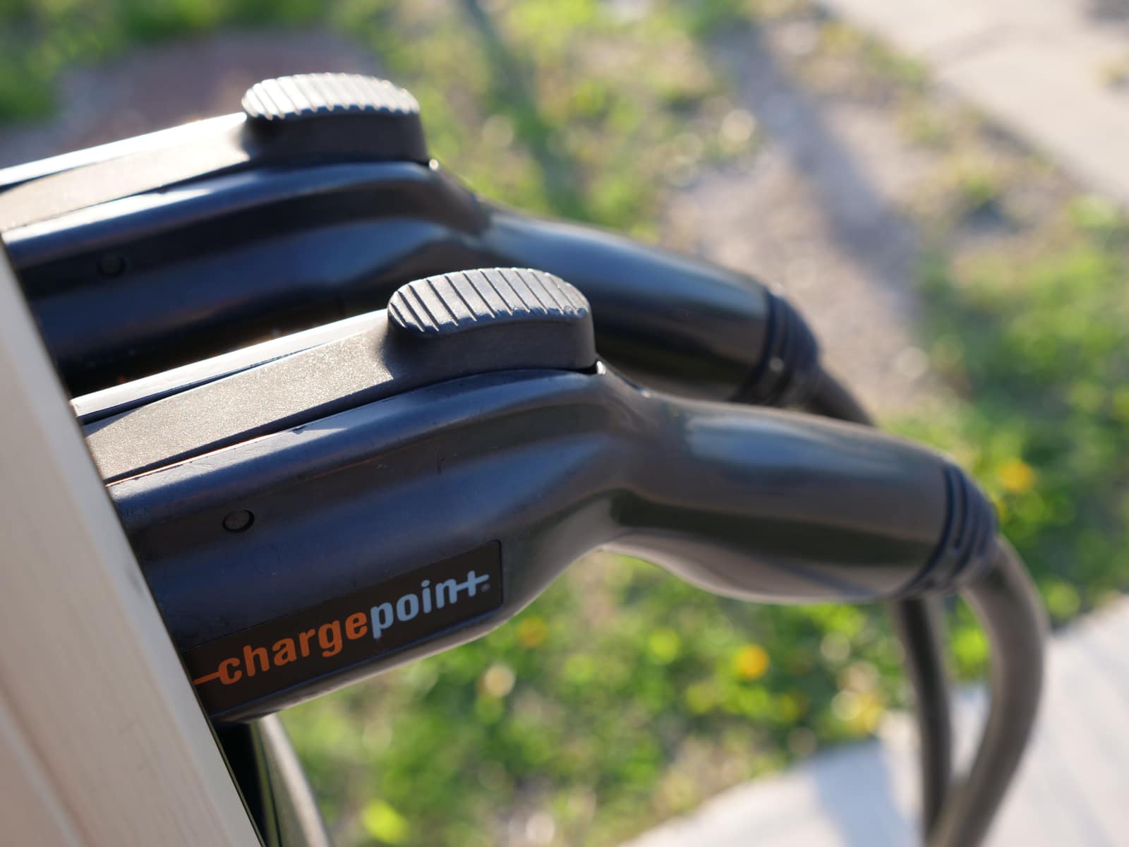 ChargePoint J1772 charging connectors holstered on a charging station