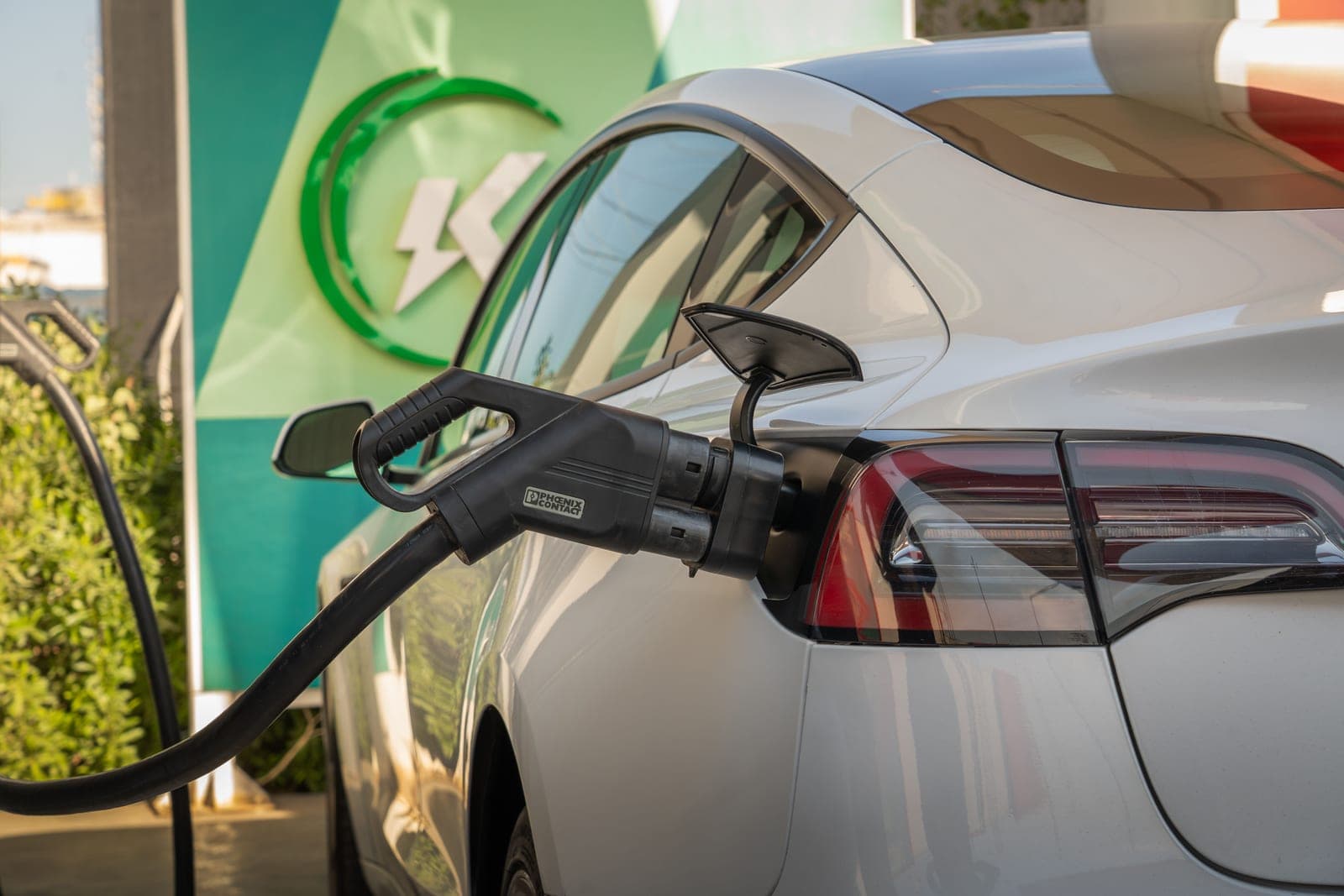 An electric vehicle charging connector plugged into a car port