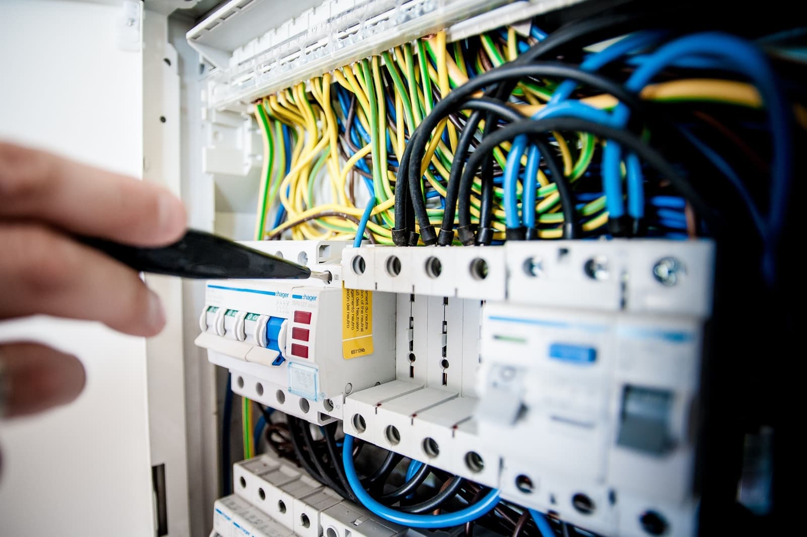 A hand resetting a switch on a residential electrical panel